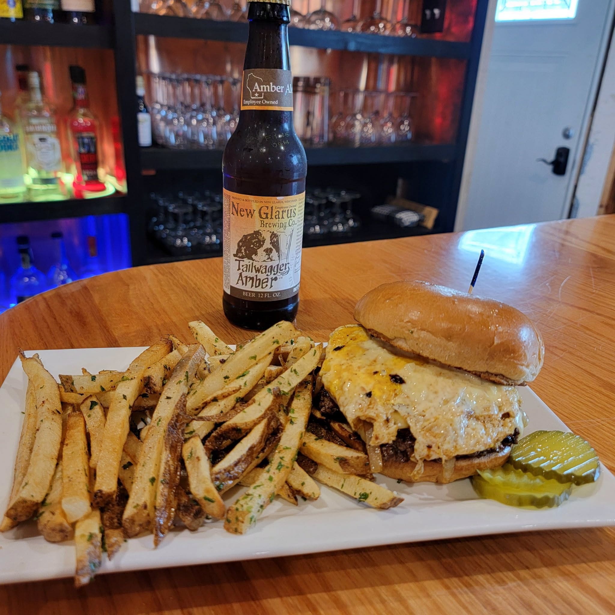 Smash burger with caramelized onions, cheese, and house-cut fries with a New Glarus Tailwagger Amber