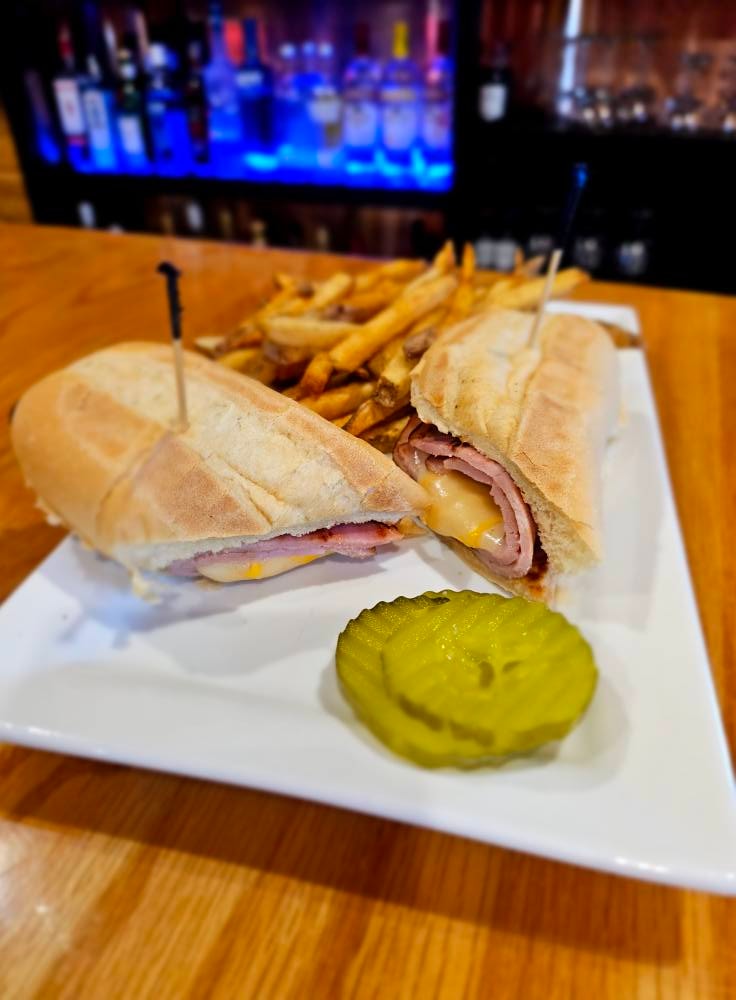 Ham and cheese sandwich on a hoagie roll with house-cut fries and pickle